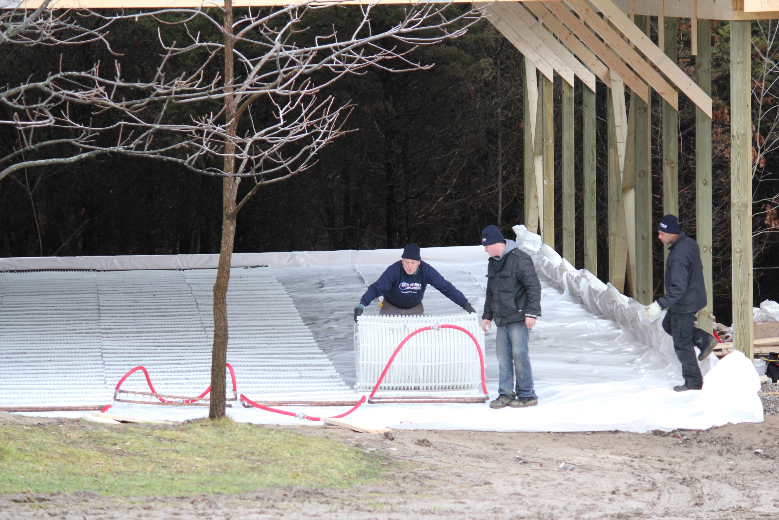 A diverse group of individuals collaborates on an ice rink, engaged in various activities related to ice sports.