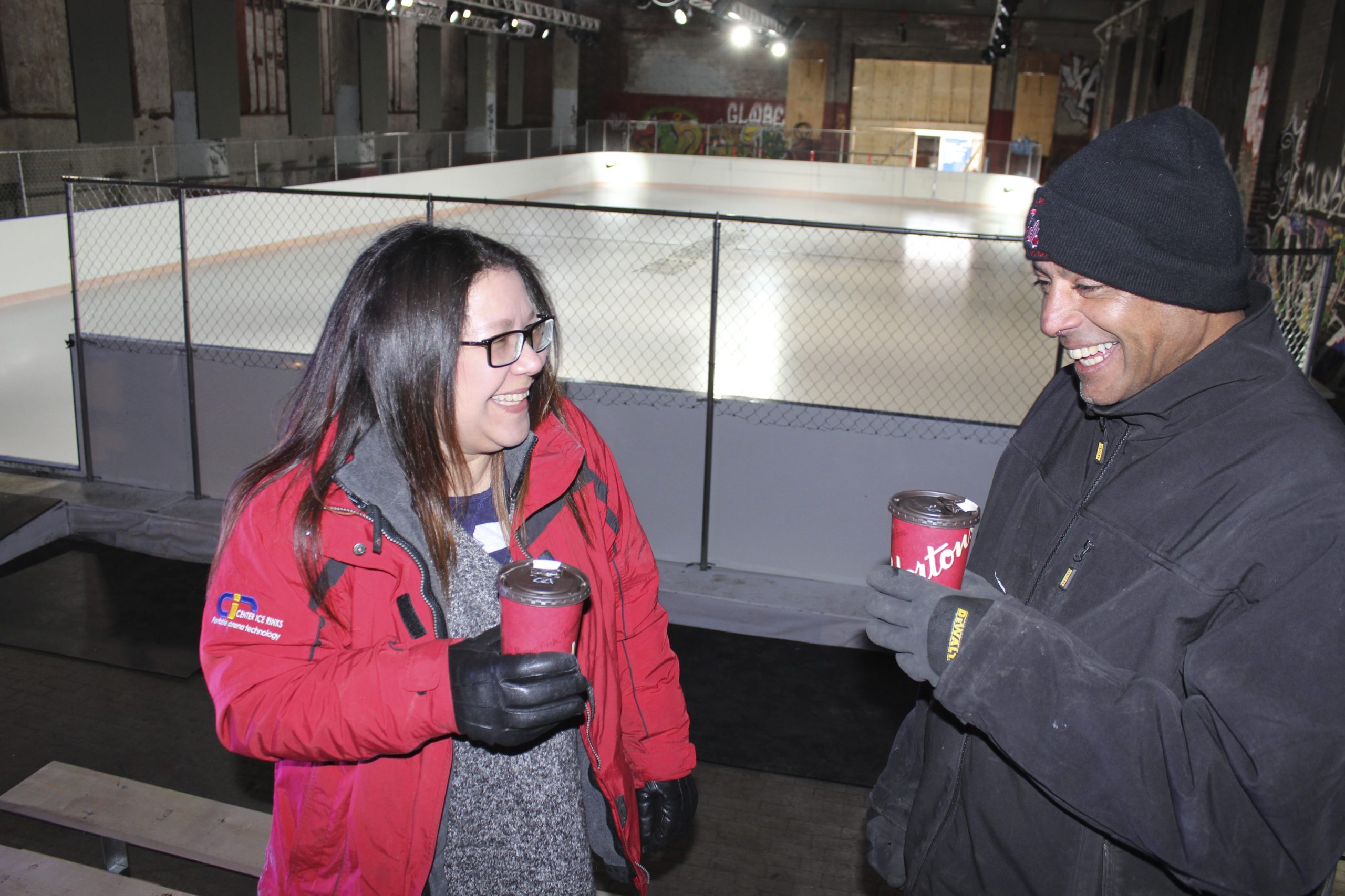 Man and woman holding a coffee cup while smiling