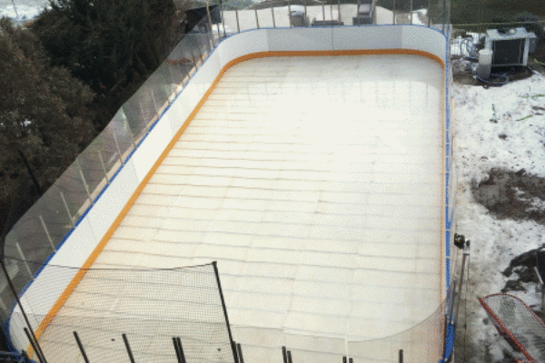 An ice rink enclosed by a fence, showcasing a smooth surface ready for skating activities.