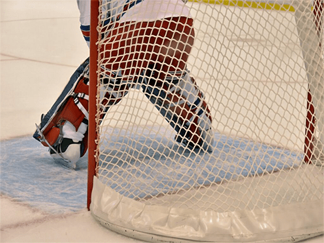 The goalie positions himself, ready to block an incoming shot in a high-stakes match.