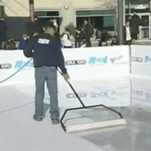 Ice rink in downtown Chicago, surrounded by city buildings, with skaters enjoying a winter day under a clear blue sky.