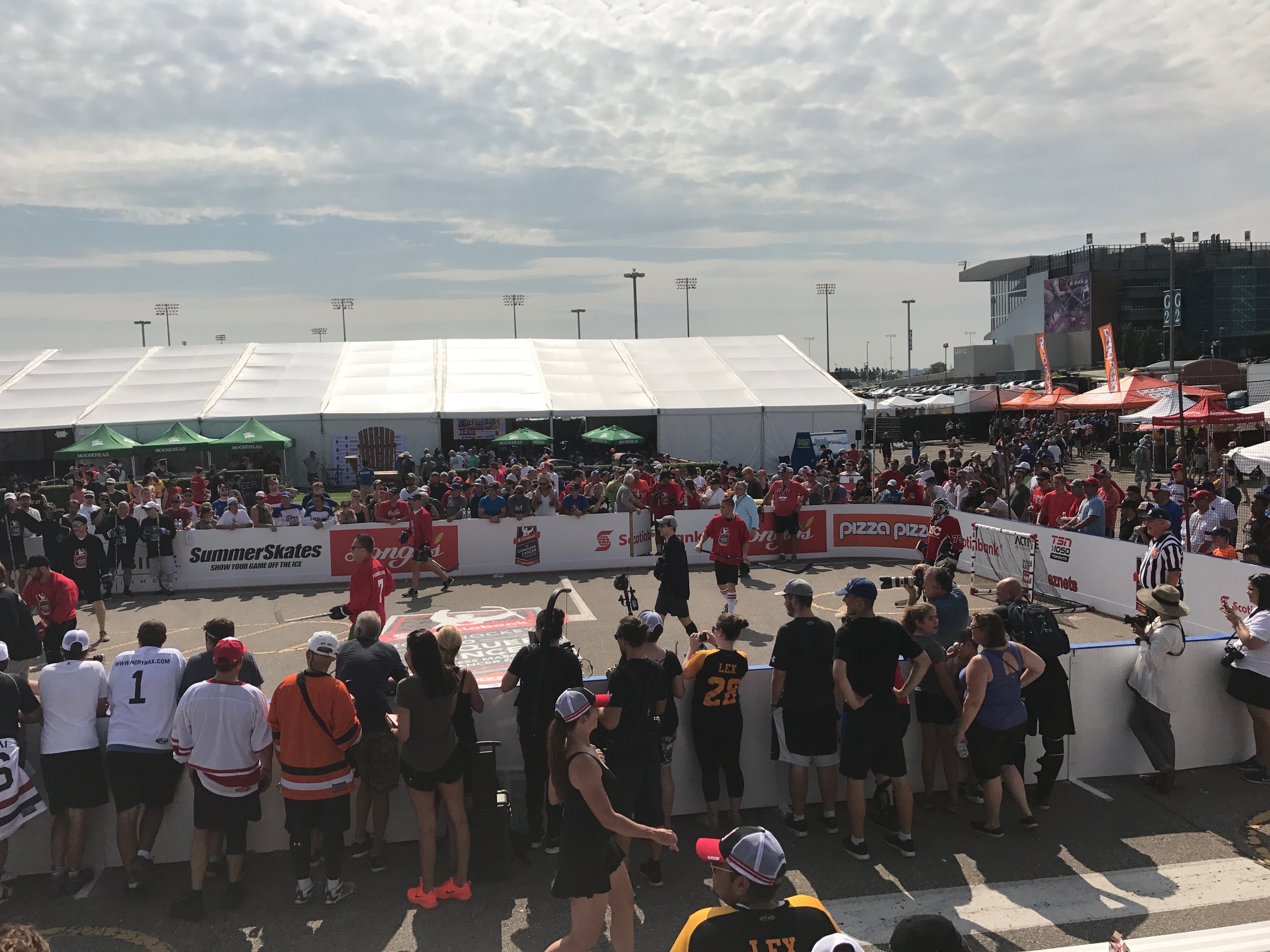 Spectators form a crowd around a basketball court, eagerly watching the action unfold during the game.